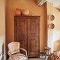 Holiday bedroom, de muren in Faded Terracotta van Farrow & Ball x Kelly Wearstler. De antieke stoel werd bekleed met stof van Dedar. De Spaanse keramieken schalen zijn te koop bij Noëlle in de studio. Linkerfoto: Justin Michel,